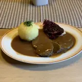 Deftig geschmortes Rindfleisch in dunkler Sauce mit Klößen und Rotkohl. Ein Klassiker, der an Omas **Treber Rezepte** erinnert.