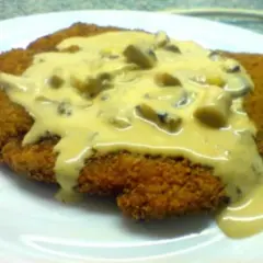 Ein knuspriges Schnitzel, bedeckt mit einer cremigen Pilzsoße, wie vom Braumeister serviert.