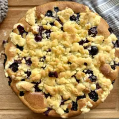 Ein goldbrauner Heidelbeer Streuselkuchen mit saftigen Blaubeeren und knusprigen Streuseln, bereit zum Genießen.