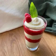 Schichtdessert im Glas mit Himbeersoße und einfacher Schmandcreme, garniert mit frischen Himbeeren und Minze.