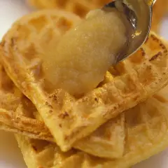 Goldbraune Waffeln, gestapelt und mit einem Löffel Apfelmus bedeckt. Ein süßer Genuss!