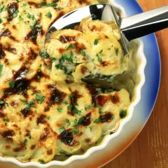 Herzhaftes Mangold-Kartoffel-Gratin mit goldbrauner Käsekruste, garniert mit frischer Petersilie. Ein köstliches Rezept!