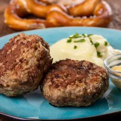 Zwei goldbraune Frikadellen mit Kartoffelbrei und Senf. Dieses Gericht ist ein Beweis für das beste Frikadellen Rezept, das man sich wünschen kann.
