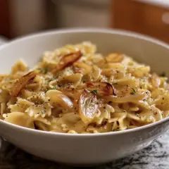 Schmetterlingsnudeln mit karamellisierten Zwiebeln und Kräutern. Ein Beweis für schnelle Rezepte mit Zwiebeln, die köstlich sind.