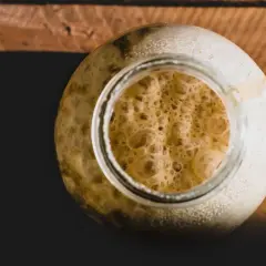 Blubbernder Sauerteig im Glas, voller aktiver Hefe und Bakterien, bereit zum Backen.