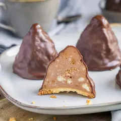 Schokoladen-Desserts, die an Granatsplitter erinnern, auf einem Teller. Ein Stück ist angeschnitten und zeigt die cremige Füllung mit Keksstückchen. Ein tolles granatsplitter rezept.