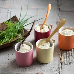 Vier bunte Tassen mit cremiger Remoulade, dazu frische Kräuter. Ein einfaches Remoulade Rezept zum Nachmachen.
