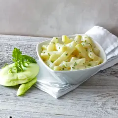 Kohlrabi in cremiger Sauce, bereit für die Kochzeit. Daneben ein frischer Kohlrabi mit Grün.