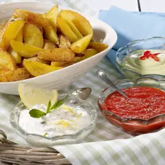 Knusprige Kartoffelecken mit drei Dips: ein cremiger Dip mit Chili, ein roter Dip und ein Joghurt-Dip mit Zitrone und Minze. Perfekt zum Teilen!