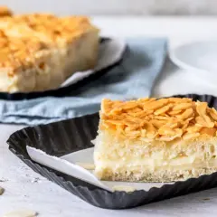 Ein Stück vom Blechkuchen-Bienenstich-Rezept, mit cremiger Füllung und knusprigen Mandeln.
