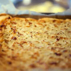 Frisch gebackener Zwiebelkuchen im Blech, ein köstliches zwiebelkuchen originalrezept mit Speck und Kümmel.