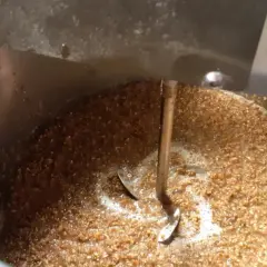 Ein Rührwerk mischt Malzschrot in einem Kessel für die Bierinfusion.