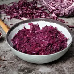 Schon probiert? Dieses rotkohl rezept einfach ist ein Genuss! Serviert in einer Schüssel, daneben ein Löffel, Gewürznelken und Preiselbeeren.