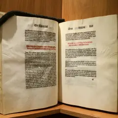 Altes Buch mit lateinischem Text. Ein schwarzes Band hält die Seiten zusammen. Das **deutsche Reinheitsgebot** von 1516 wird hier in alter Schrift zitiert.
