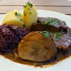 Schmorbraten vom Hirsch, zart und saftig, mit Salzkartoffeln und Rotkohl. Ein klassisches Rezept für Hirschbraten geschmort.
