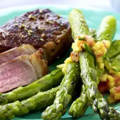 Saftiger Rumpsteak in der Pfanne, medium gebraten, serviert mit grünem Spargel und einer fruchtigen Salsa.