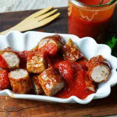 Eine Portion Currywurst mit Pommes, übergossen mit einer würzigen Sauce. Ein Klassiker, der immer schmeckt!