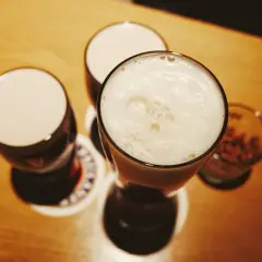 Drei Gläser mit Schaumkrone und ein Glas mit Nüssen – perfekte blindverkostung ideen für einen gemütlichen Abend.