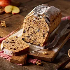 Ein saftiges Apfelbrot mit Rosinen und Nüssen, bestäubt mit Puderzucker. Perfekt für ein gemütliches Apfelbrot Rezept.