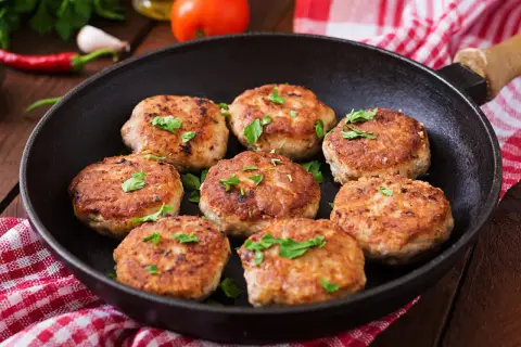 Frisch gebratene Frikadellen im Gusseisen-Pfännchen, garniert mit Petersilie. Ein leckeres Frikadellen Rezept für jeden Anlass.