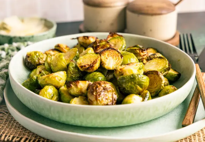 Knuspriger rosenkohl im airfryer, goldbraun und appetitlich in einer Schüssel serviert.