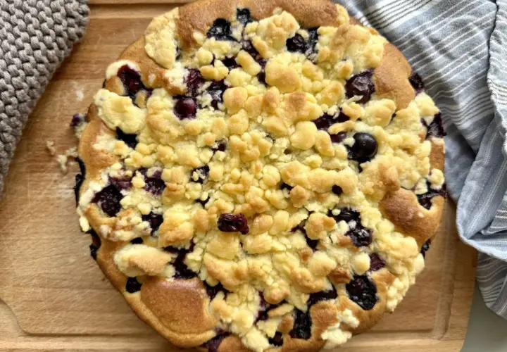 Ein goldbrauner Heidelbeer Streuselkuchen mit saftigen Blaubeeren und knusprigen Streuseln, bereit zum Genießen.
