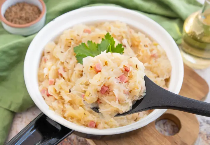 Herzhaftes Sauerkraut aus dem Glas zubereiten, mit Speck und Kümmel verfeinert. Ein Löffel voller Genuss!