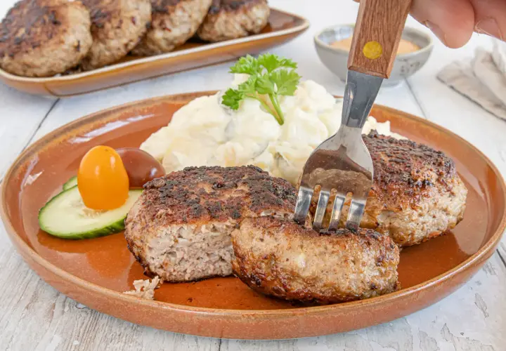 Beefsteak nach Omas Rezept: saftige Frikadellen mit Kartoffelsalat und Gurke, ein Klassiker, der immer schmeckt.