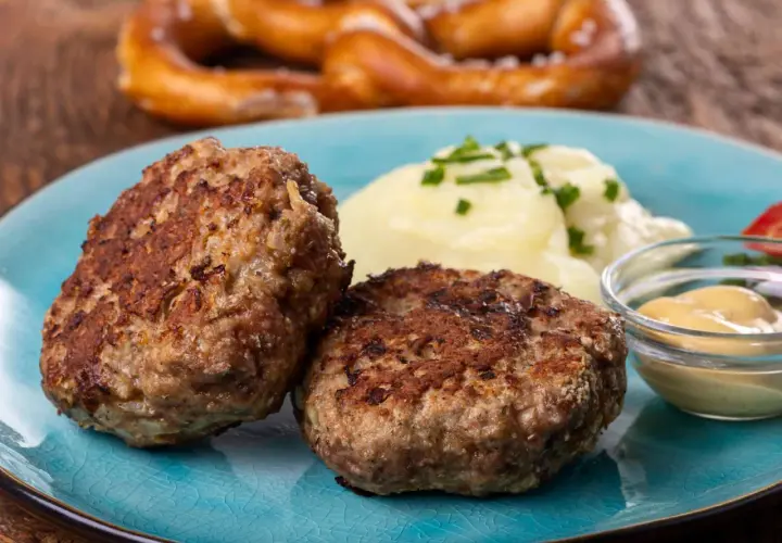 Zwei goldbraune Frikadellen mit Kartoffelbrei und Senf. Dieses Gericht ist ein Beweis für das beste Frikadellen Rezept, das man sich wünschen kann.
