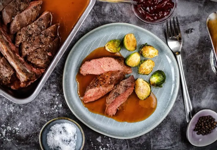 Zart geschnittener Rehbraten in Rotwein-Sauce mit Rosenkohl. Ein Festmahl, das auf der Zunge zergeht.