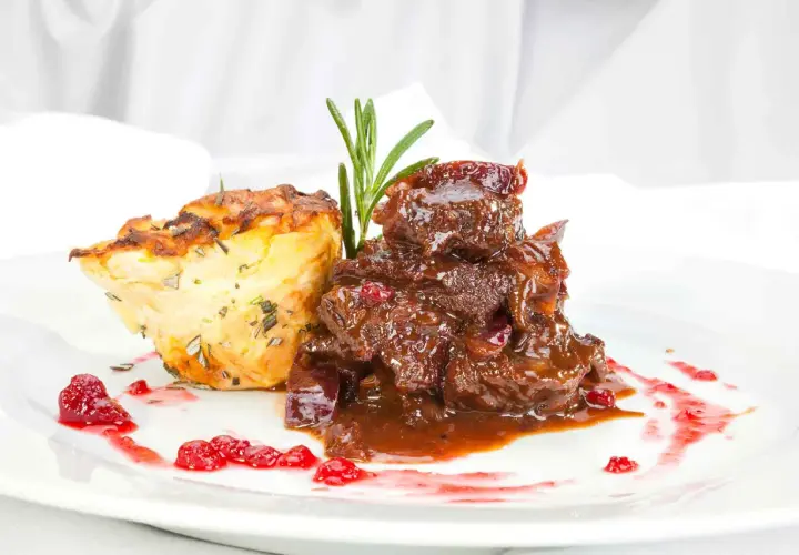Deftiges Gulasch mit Preiselbeeren und Kartoffelgratin. Einfache reh rezepte für ein festliches Essen.