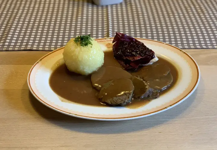 Deftig geschmortes Rindfleisch in dunkler Sauce mit Klößen und Rotkohl. Ein Klassiker, der an Omas **Treber Rezepte** erinnert.