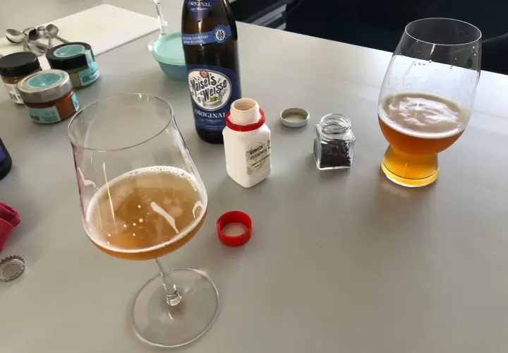 Zwei Gläser Weizenbier, eine Flasche Maisel's Weisse und kleine Gläser mit Gewürzen. Der Weizenbier Geschmack wird durch die Zutaten verfeinert.