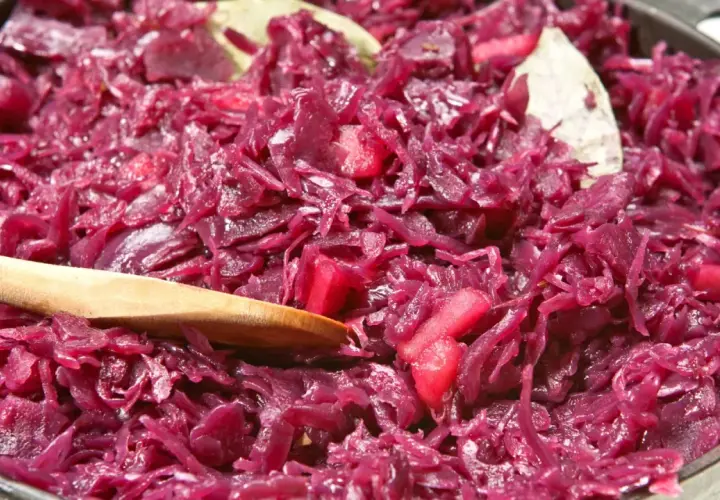Leckeres rotkohl rezept aus dem glas, mit Apfelstücken und Lorbeerblättern, bereit zum Servieren.