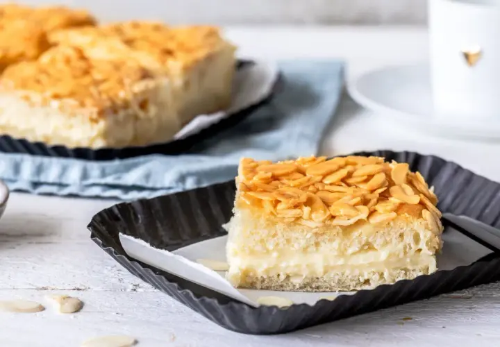 Ein Stück vom Blechkuchen-Bienenstich-Rezept, mit cremiger Füllung und knusprigen Mandeln.