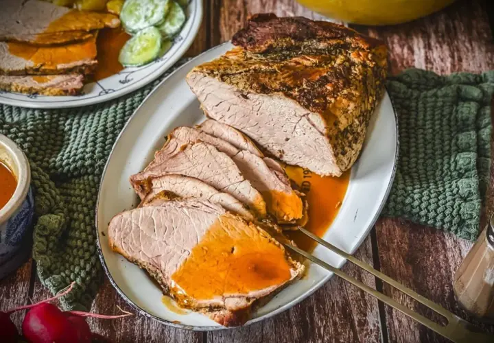 Saftiger Schweinebraten, perfekt gegart bei der richtigen Schweinebraten Temperatur Umluft. Serviert mit Sauce und Beilagen.
