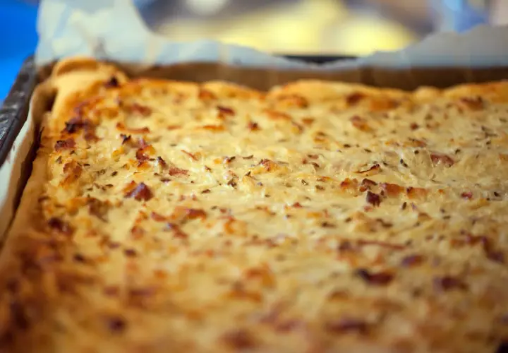 Frisch gebackener Zwiebelkuchen im Blech, ein köstliches zwiebelkuchen originalrezept mit Speck und Kümmel.