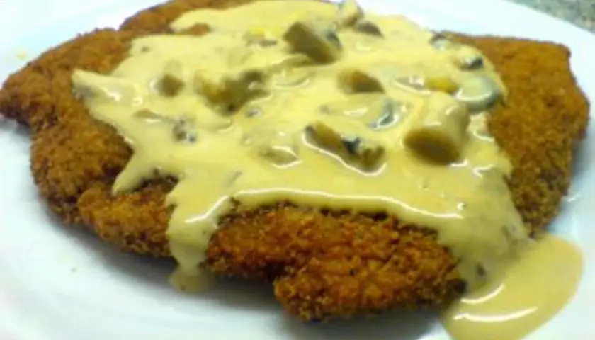 Ein knuspriges Schnitzel, bedeckt mit einer cremigen Pilzsoße, wie vom Braumeister serviert.
