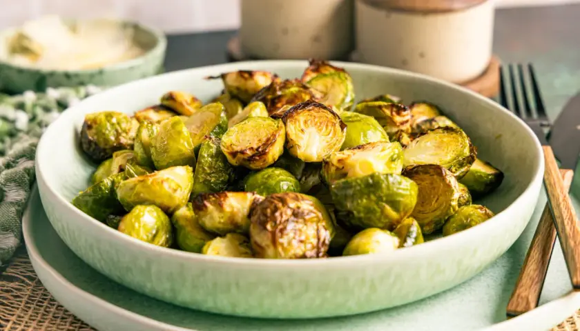 Knuspriger rosenkohl im airfryer, goldbraun und appetitlich in einer Schüssel serviert.