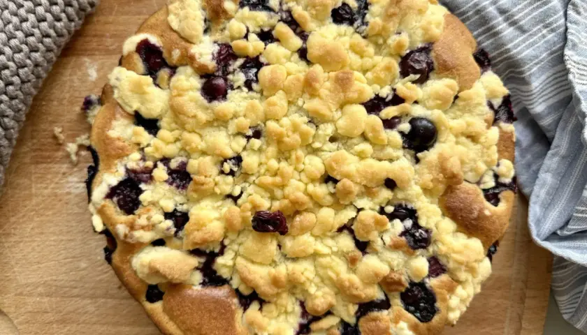 Ein goldbrauner Heidelbeer Streuselkuchen mit saftigen Blaubeeren und knusprigen Streuseln, bereit zum Genießen.