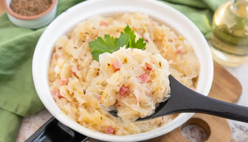 Herzhaftes Sauerkraut aus dem Glas zubereiten, mit Speck und Kümmel verfeinert. Ein Löffel voller Genuss!