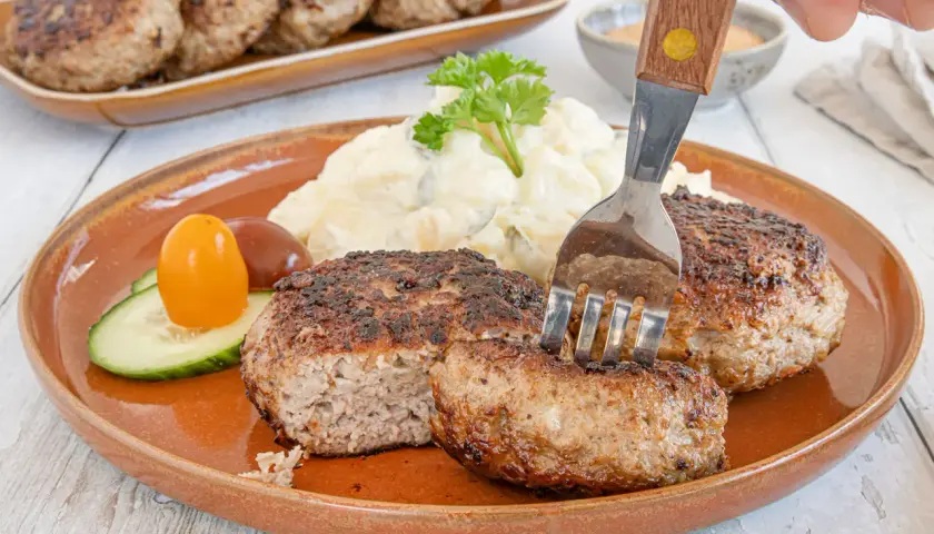 Beefsteak nach Omas Rezept: saftige Frikadellen mit Kartoffelsalat und Gurke, ein Klassiker, der immer schmeckt.