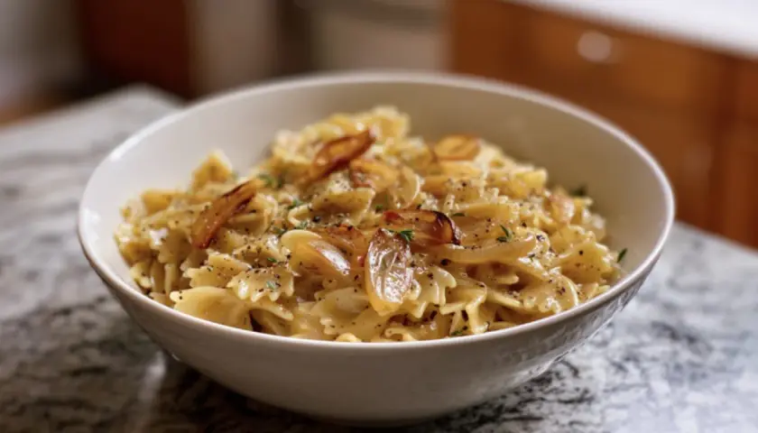Schmetterlingsnudeln mit karamellisierten Zwiebeln und Kräutern. Ein Beweis für schnelle Rezepte mit Zwiebeln, die köstlich sind.