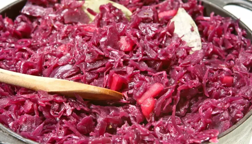 Leckeres rotkohl rezept aus dem glas, mit Apfelstücken und Lorbeerblättern, bereit zum Servieren.
