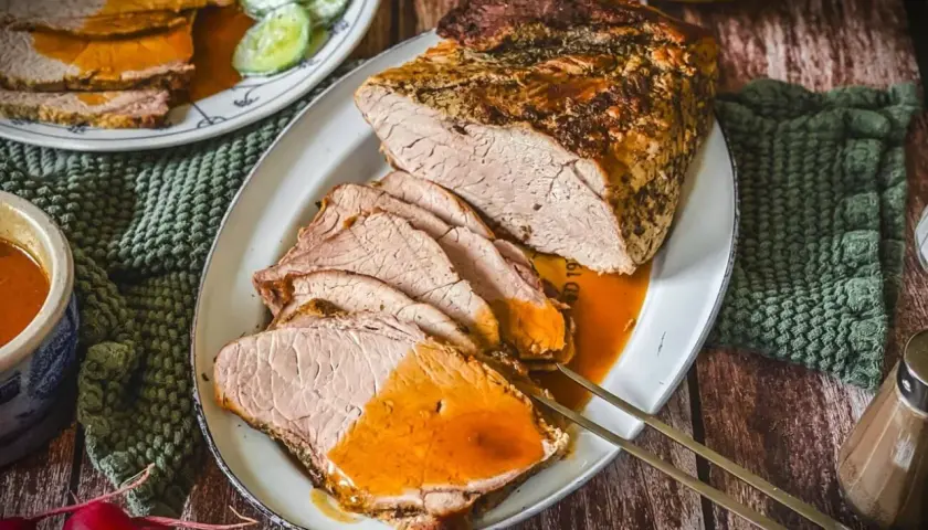 Saftiger Schweinebraten, perfekt gegart bei der richtigen Schweinebraten Temperatur Umluft. Serviert mit Sauce und Beilagen.