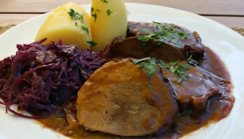 Schmorbraten vom Hirsch, zart und saftig, mit Salzkartoffeln und Rotkohl. Ein klassisches Rezept für Hirschbraten geschmort.