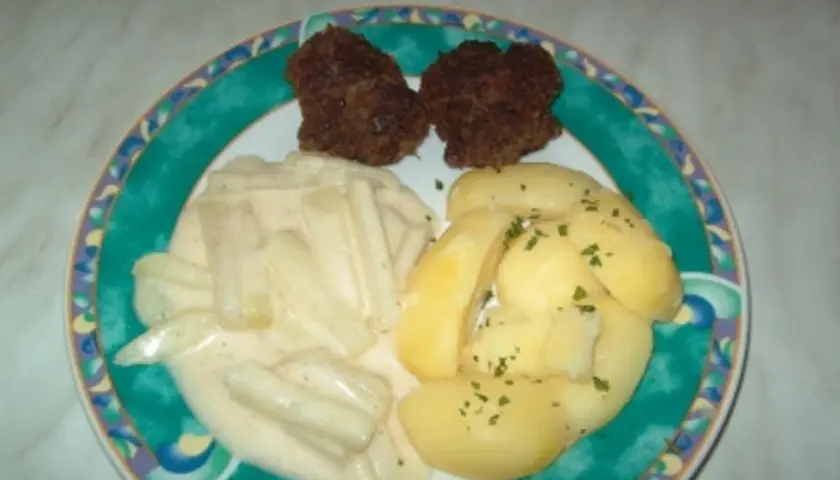 Zwei Frikadellen mit Salzkartoffeln und Kohlrabi in heller Soße. Ein leckeres Gericht, das zeigt, wie vielseitig Kohlrabi Rezepte sein können.