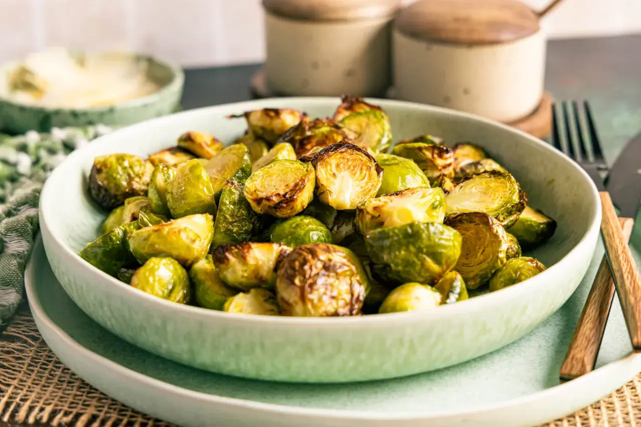 Knuspriger rosenkohl im airfryer, goldbraun und appetitlich in einer Schüssel serviert.