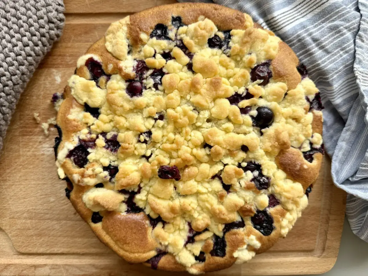 Ein goldbrauner Heidelbeer Streuselkuchen mit saftigen Blaubeeren und knusprigen Streuseln, bereit zum Genießen.