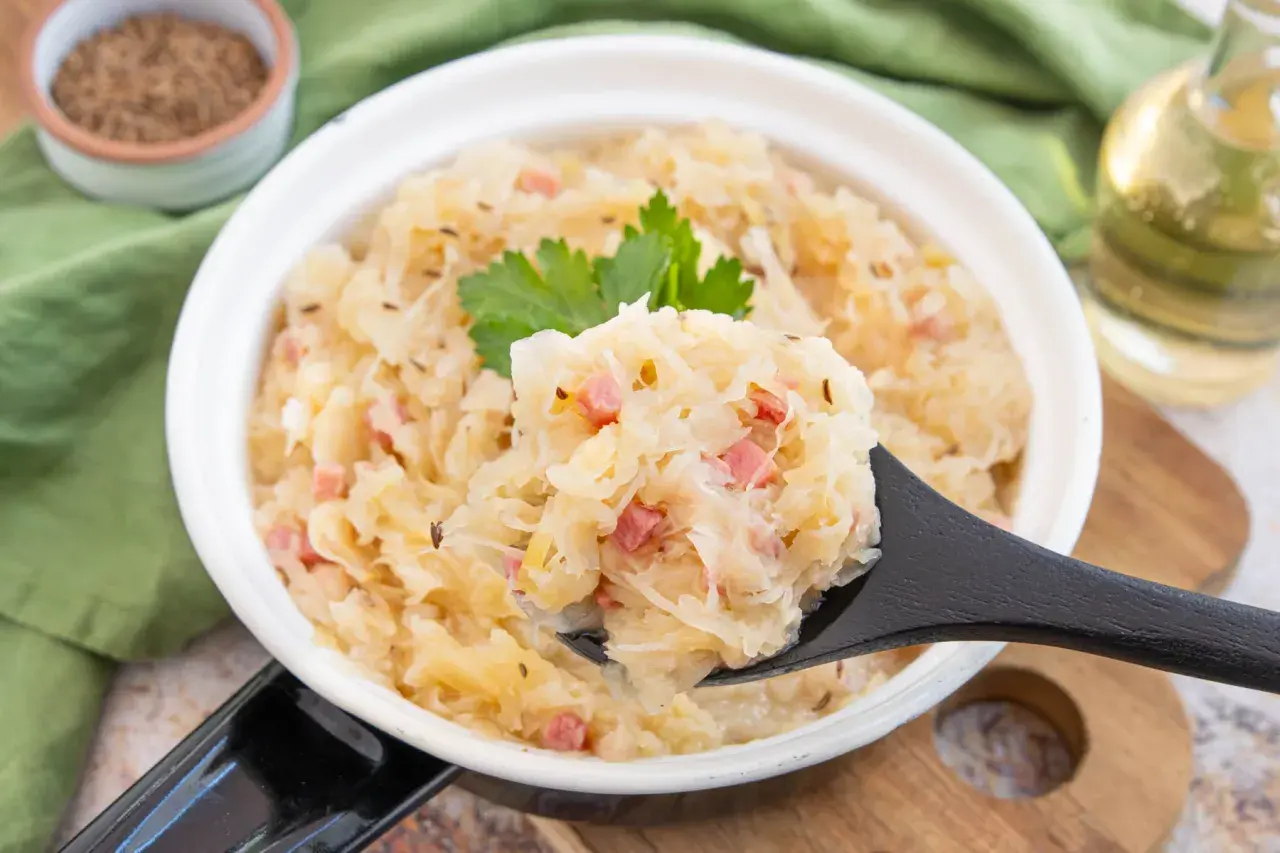 Herzhaftes Sauerkraut aus dem Glas zubereiten, mit Speck und Kümmel verfeinert. Ein Löffel voller Genuss!